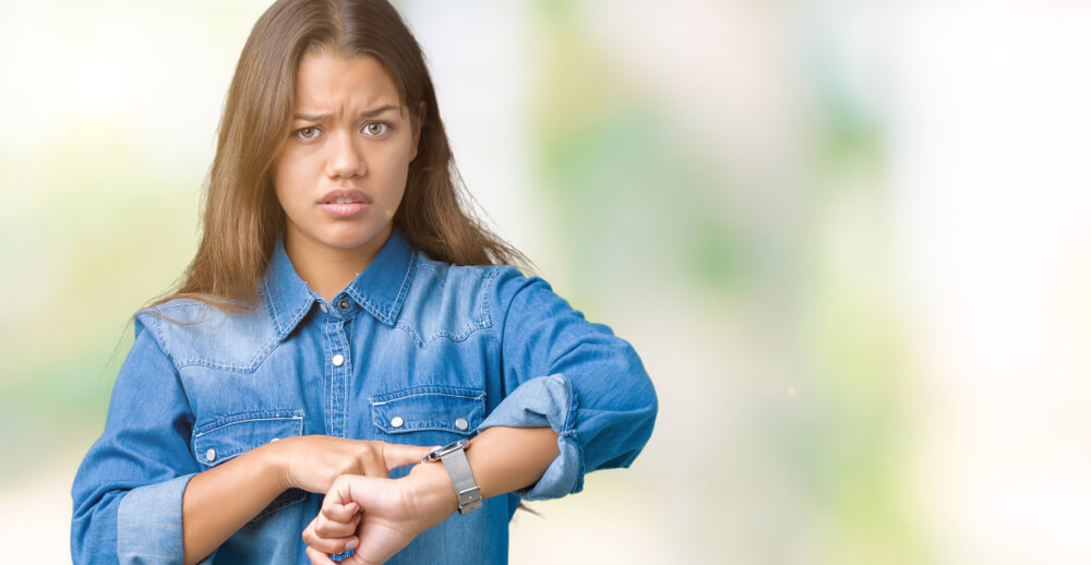 時計を指差しながら怒っている女性